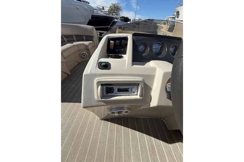 Slide: The Image of 2016 Bennington SX22 boat dashboard with gauges and controls, featuring beige interior. - 19