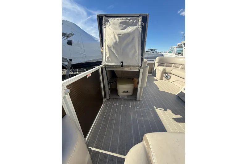 Slide: The Image of 2016 Bennington SX22 boat interior with open storage compartment and seating area. - 21