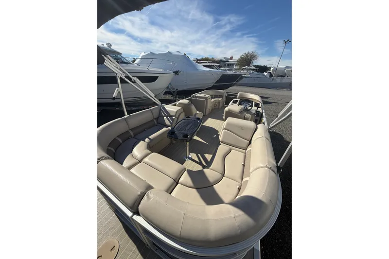 Slide: The Image of 2016 Bennington SX22 pontoon boat with beige seating and sleek design, docked outdoors. - 7
