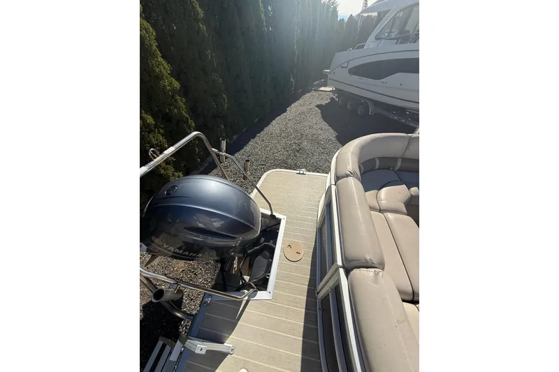 Slide: The Image of 2016 Bennington SX22 pontoon boat with Yamaha outboard motor, beige seating, and docked on gravel. - 8