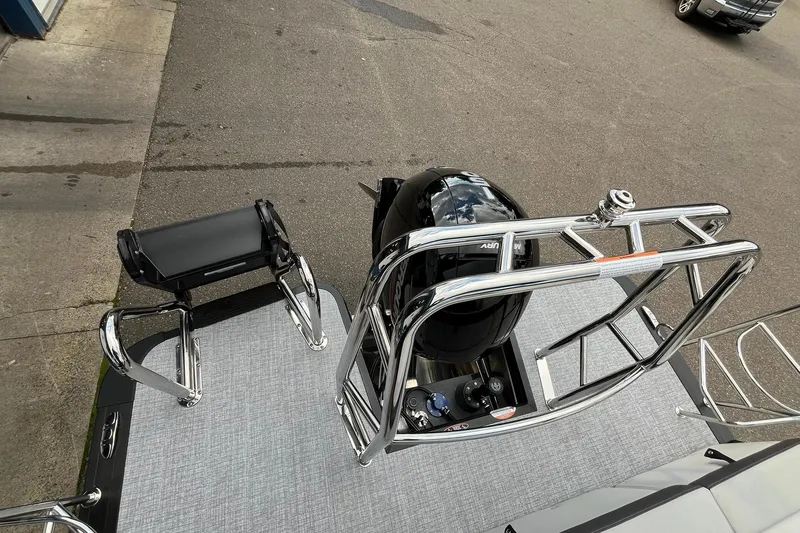 Slide: The Image of 2026 Harris Cruiser 230 boat with sleek chrome railing and powerful Mercury engine. - 16