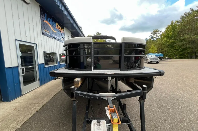 Slide: The Image of 2026 Harris Cruiser 230 pontoon boat on trailer outside dealership. - 30