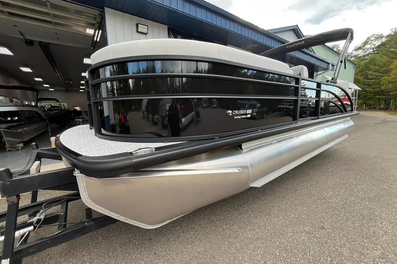 Slide: The Image of 2026 Harris Cruiser 230 pontoon boat parked outside a building. - 31