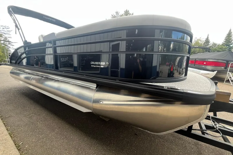 Slide: The Image of 2026 Harris Cruiser 230 pontoon boat, sleek design, parked on a trailer. - 5