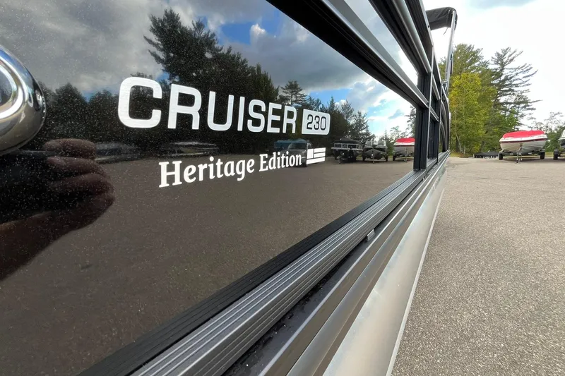 Slide: The Image of 2026 Harris Cruiser 230 Heritage Edition boat, side view with reflection. - 8