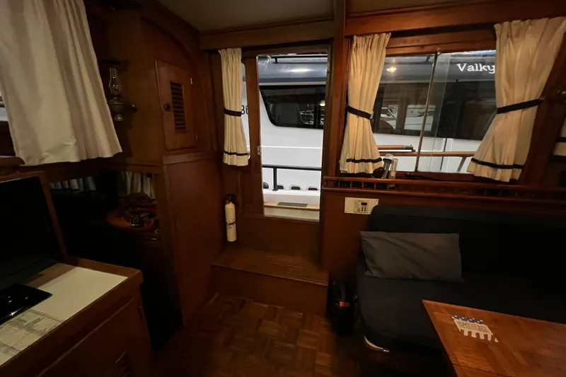 Slide: The Image of Cozy interior of a 1979 Litton Trawler with wooden table and cushioned seating. - 6