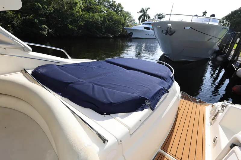 Slide: The Image of 2007 Cranchi Mediterranee 50 HT yacht with blue cover, docked near lush greenery. - 17