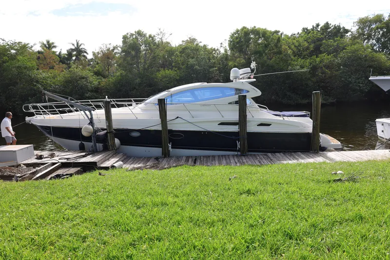 Slide: The Image of 2007 Cranchi Mediterranee 50 HT yacht docked by a lush riverside. - 2