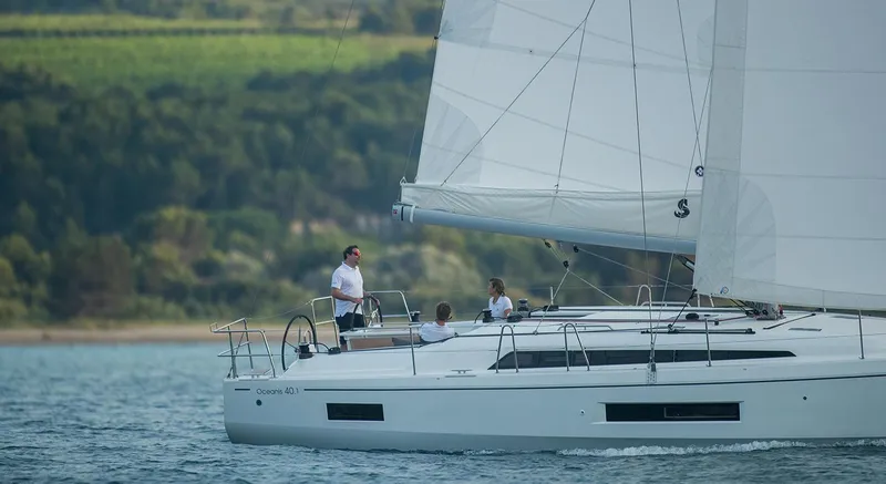 Slide: The Image of 2026 Beneteau Oceanis 40.1 sailing on a serene lake with lush green hills. - 8