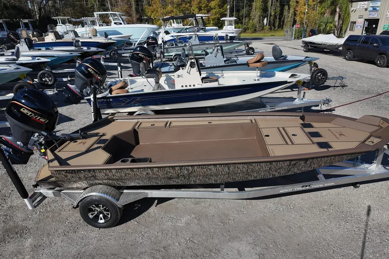 Slide: The Image of 2026 Xpress X18DB boat on trailer, surrounded by other boats in a dealership lot. - 1