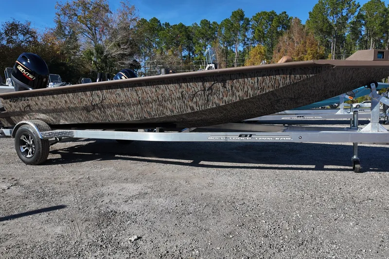 Slide: The Image of 2026 Xpress X18DB boat on trailer, camo design, parked outdoors. - 6