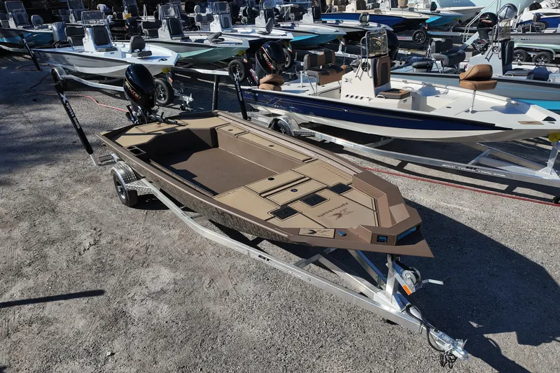 Slide: The Image of 2026 Xpress X18DB boat on trailer, surrounded by other boats in a lot. - 7