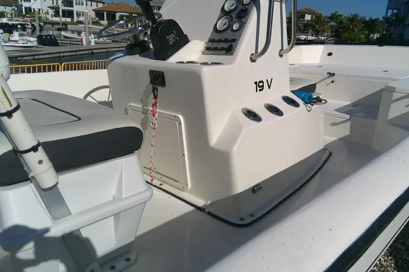Slide: The Image of Outcast 19V boat interior, 2017 model, featuring control panel and seating in a marina setting. - 17