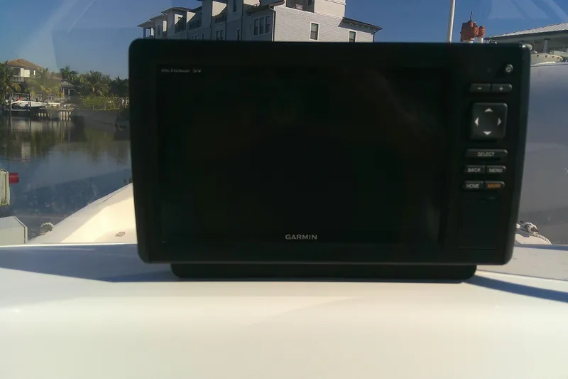 Slide: The Image of Garmin device on 2017 Outcast 19V boat dashboard, waterfront view. - 23