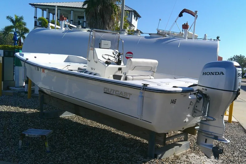 Slide: The Image of 2017 Outcast 19V boat with Honda outboard motor, parked on gravel. - 5