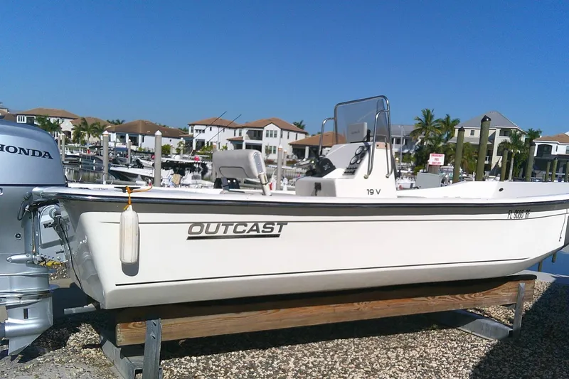 Slide: The Image of 2017 Outcast 19V boat with Honda motor, docked in a marina under clear blue sky. - 7
