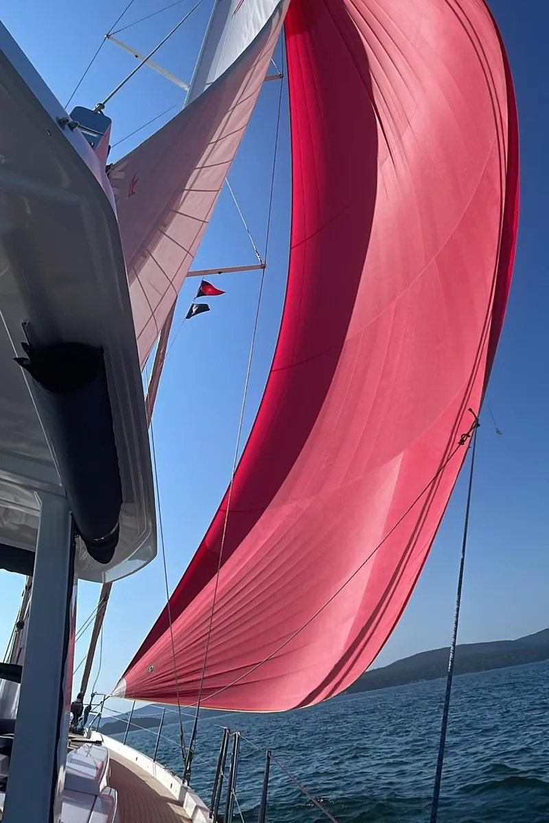 Slide: The Image of Sailing yacht Hanse 588 (2019) with vibrant red sail on open water. - 24