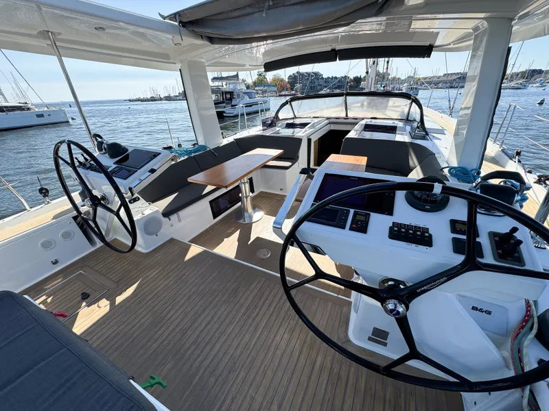 Slide: The Image of 2019 Hanse 588 yacht cockpit with dual steering wheels and spacious seating area. - 4