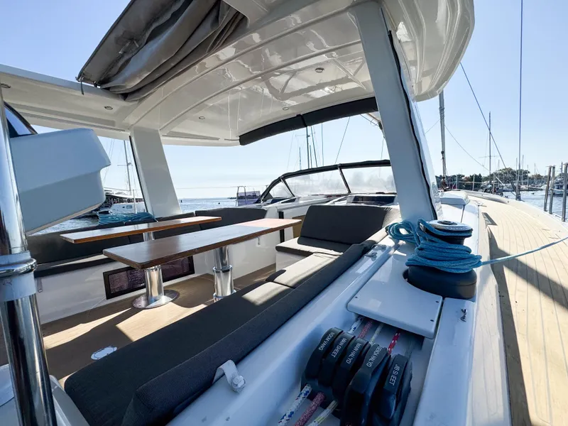 Slide: The Image of 2019 Hanse 588 yacht deck with seating and winches, docked at marina. - 6