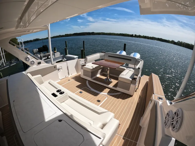 Slide: The Image of 2024 Tiara Yachts 43 LS luxury deck with seating, table, and scenic water view. - 11