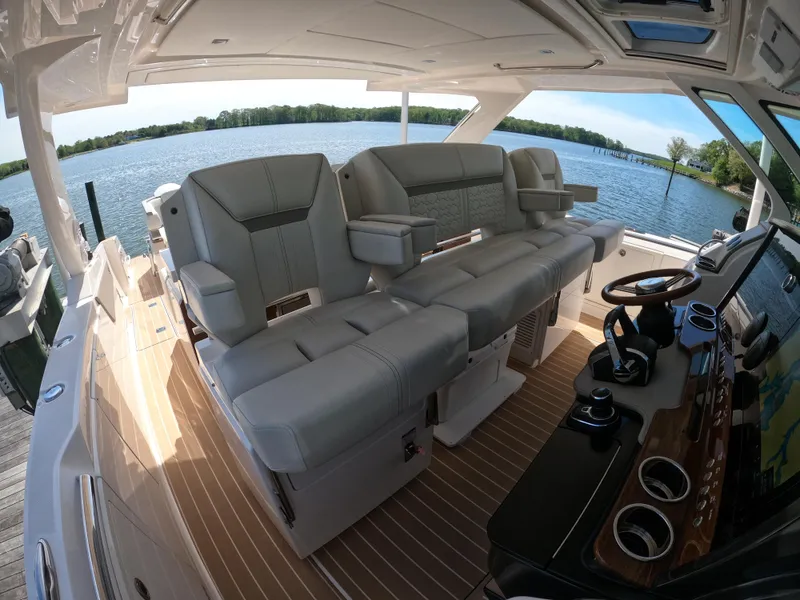 Slide: The Image of 2024 Tiara Yachts 43 LS interior with luxurious seating and modern helm, overlooking serene waters. - 18