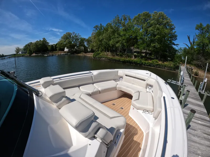 Slide: The Image of 2024 Tiara Yachts 43 LS with spacious seating, docked by a scenic waterfront. - 22
