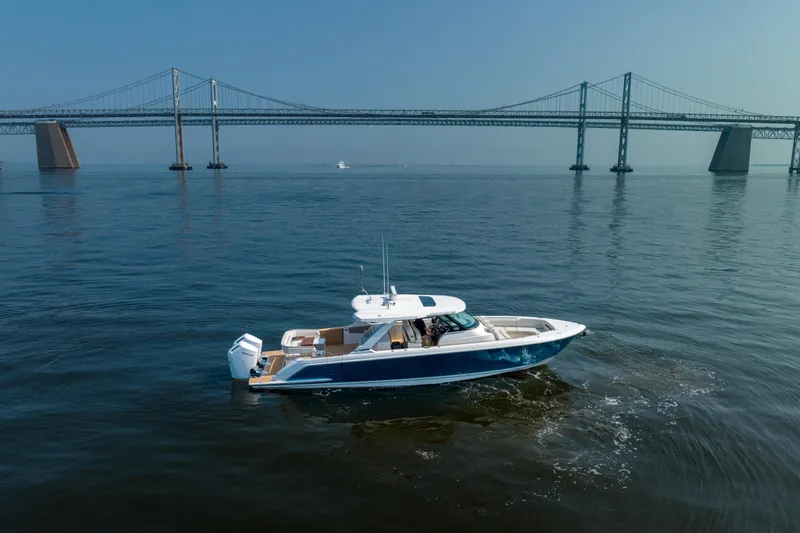 Slide: The Image of 2024 Tiara Yachts 43 LS cruising near a large bridge on calm waters. - 3