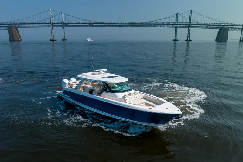 Slide: The Image of 2024 Tiara Yachts 43 LS cruising near a large bridge on calm waters. - 4