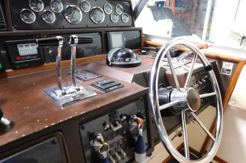 Slide: The Image of 1986 Sea Ray 390 Express Cruiser helm with steering wheel and control panel. - 11