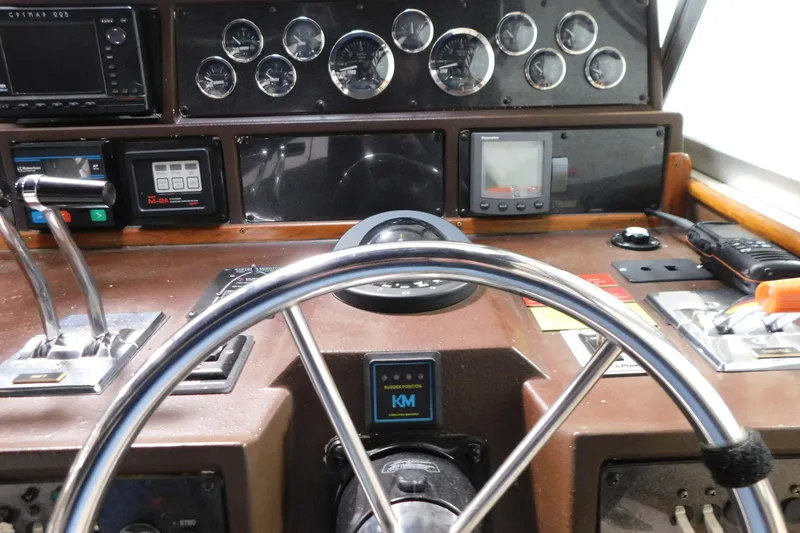 Slide: The Image of 1986 Sea Ray 390 Express Cruiser dashboard with steering wheel and navigation instruments. - 13