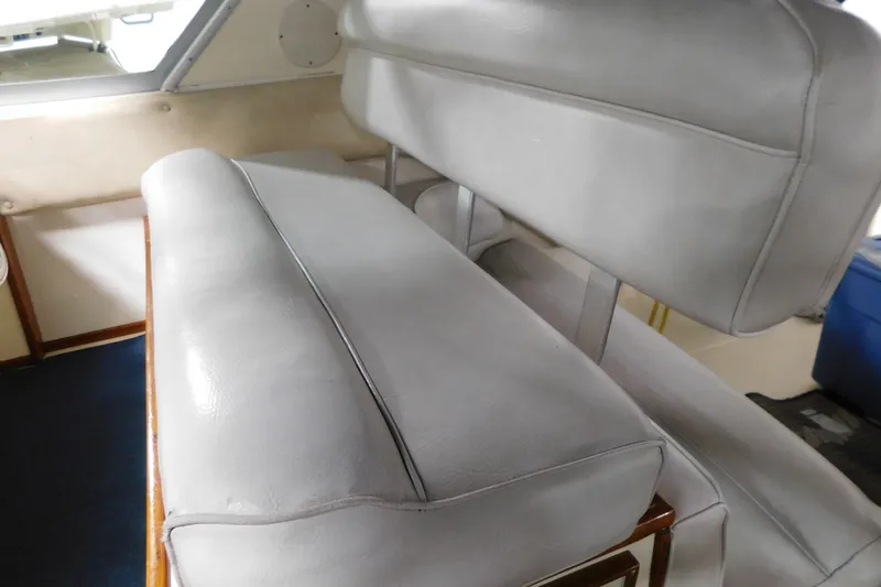 Slide: The Image of 1986 Sea Ray 390 Express Cruiser interior seating with light gray upholstery. - 17