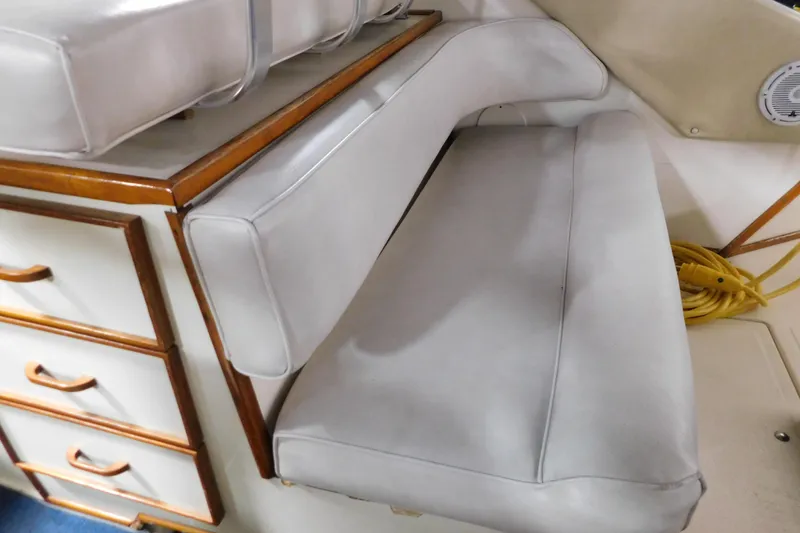 Slide: The Image of 1986 Sea Ray 390 Express Cruiser interior with cushioned seating and wooden cabinetry. - 19