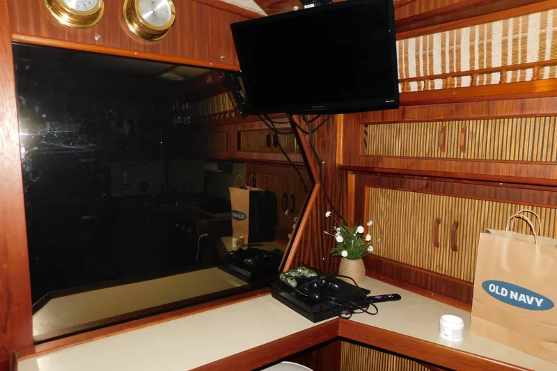 Slide: The Image of Interior of 1986 Sea Ray 390 Express Cruiser with TV, wooden cabinets, and decor. - 22