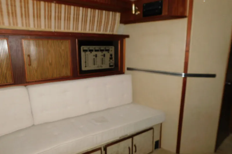 Slide: The Image of Interior of 1986 Sea Ray 390 Express Cruiser with white seating and wooden cabinetry. - 23