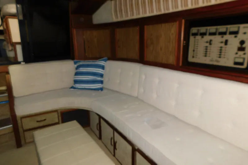 Slide: The Image of Interior of 1986 Sea Ray 390 Express Cruiser with white seating and control panel. - 24