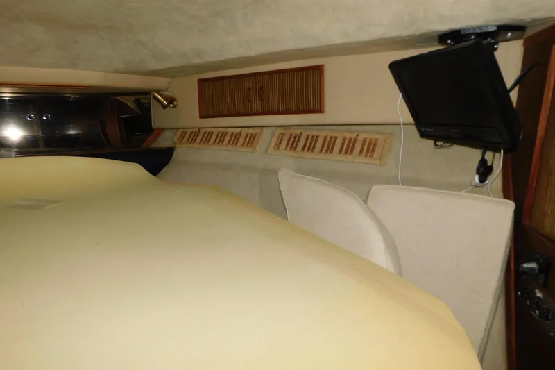 Slide: The Image of 1986 Sea Ray 390 Express Cruiser cabin interior with seating and mounted TV. - 27