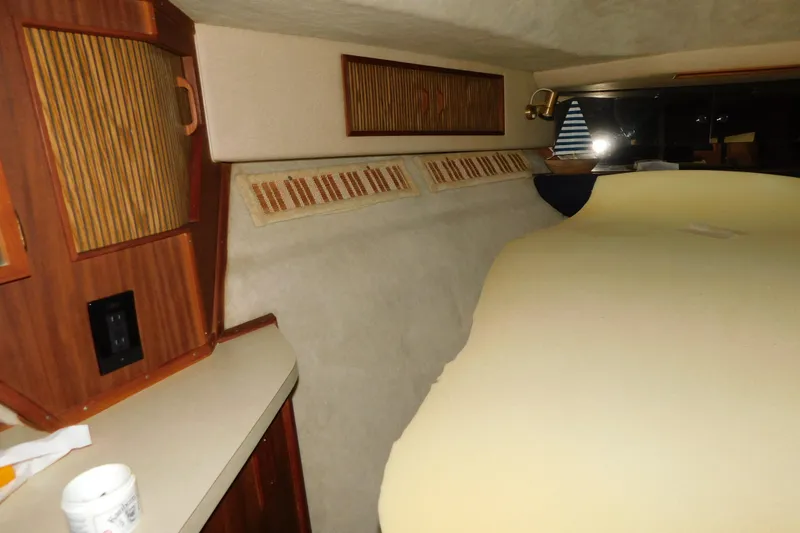 Slide: The Image of 1986 Sea Ray 390 Express Cruiser cabin interior with wood cabinetry and cozy sleeping area. - 28