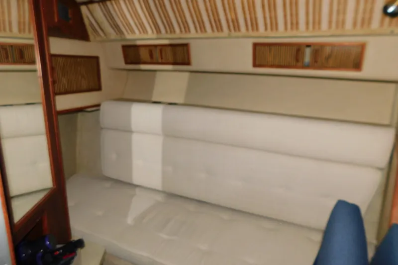 Slide: The Image of Interior of 1986 Sea Ray 390 Express Cruiser with beige seating and wood accents. - 30