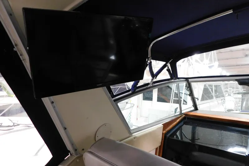 Slide: The Image of 1986 Sea Ray 390 Express Cruiser interior with mounted TV and window view. - 8