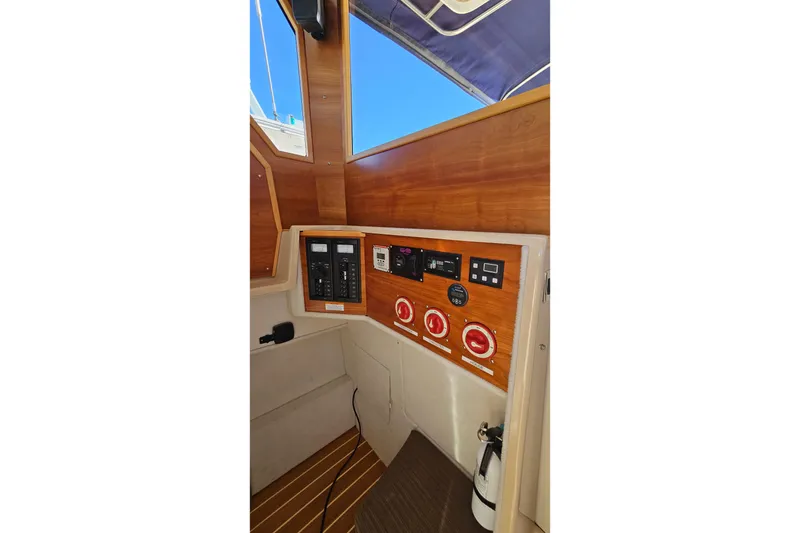 Slide: The Image of 2016 Cutwater C-28 LE boat interior control panel with wood finish and electrical switches. - 23