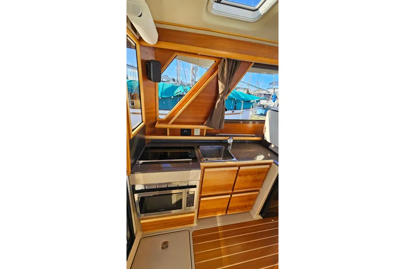Slide: The Image of 2016 Cutwater C-28 LE boat interior kitchen with wood cabinetry and appliances. - 24