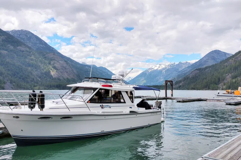 Slide: The Image of 2016 Cutwater C-28 LE boat docked on a scenic mountain lake with cloudy skies. - 4
