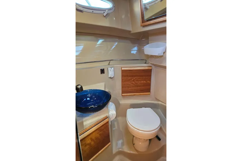 Slide: The Image of 2016 Cutwater C-28 LE boat bathroom with blue sink and wooden cabinets. - 7