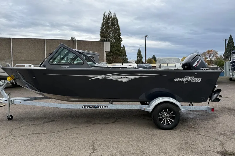 Slide: The Image of 2026 Fish Rite Sportsman 20 boat on trailer, parked outdoors, with overcast sky. - 12