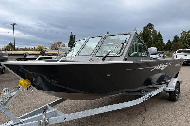 Slide: The Image of 2026 Fish Rite Sportsman 20 boat on trailer, parked outdoors under cloudy sky. - 13