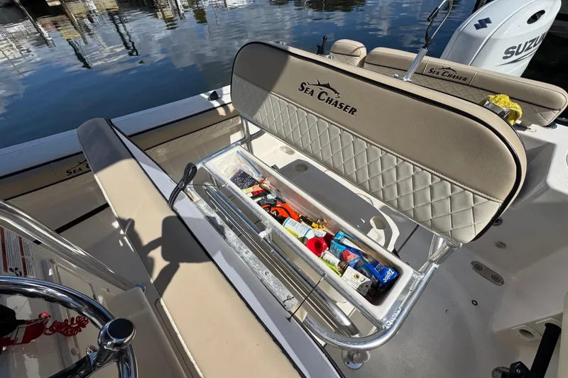Slide: The Image of 2022 Sea Chaser 22 HFC boat interior with storage compartment open, showing various items. - 13