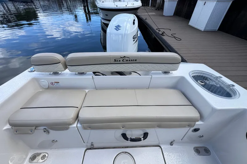 Slide: The Image of 2022 Sea Chaser 22 HFC boat interior with cushioned seating and Suzuki outboard motor. - 5