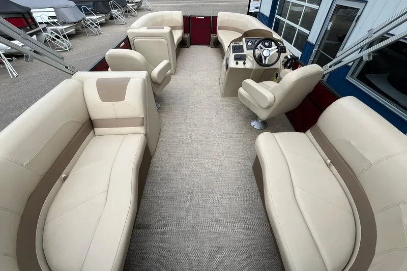 Slide: The Image of 2017 Crest I 220 L pontoon boat interior with beige seating and steering console. - 16