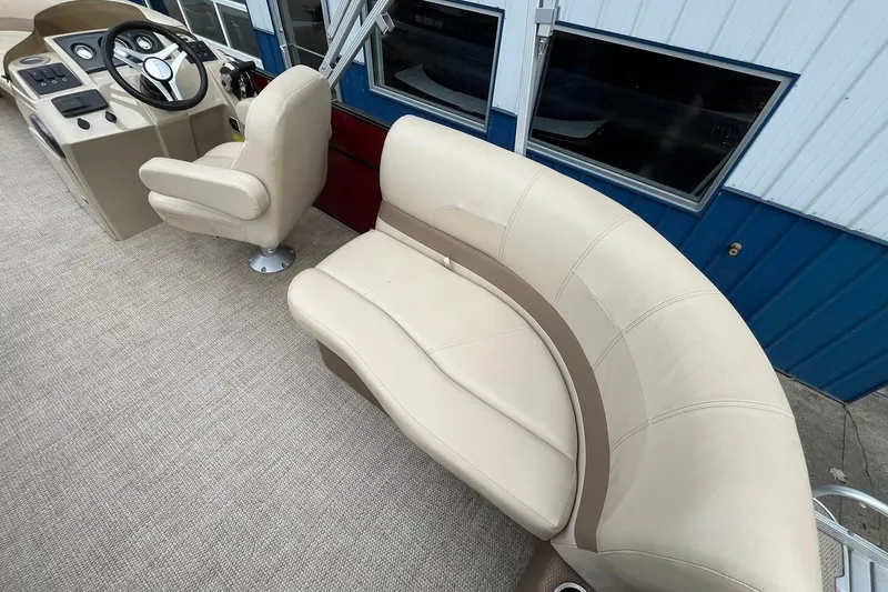 Slide: The Image of 2017 Crest I 220 L boat interior with beige seating and steering console. - 18