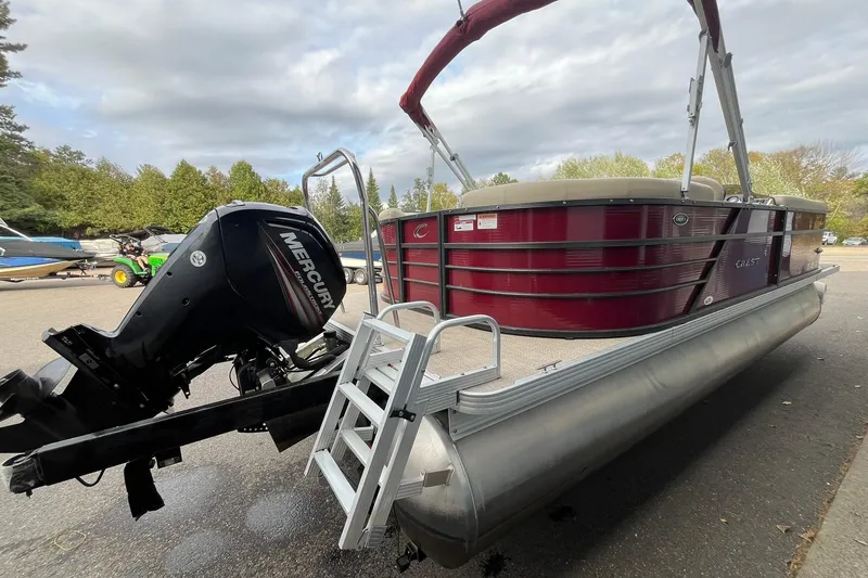 Slide: The Image of 2017 Crest I 220 L pontoon boat with Mercury outboard motor, parked outdoors. - 4